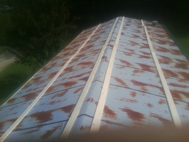 Rusted metal roof panels with new wood purlins before replacement — Storm Damage Roof Repair in Spurger by Roofing Brothers