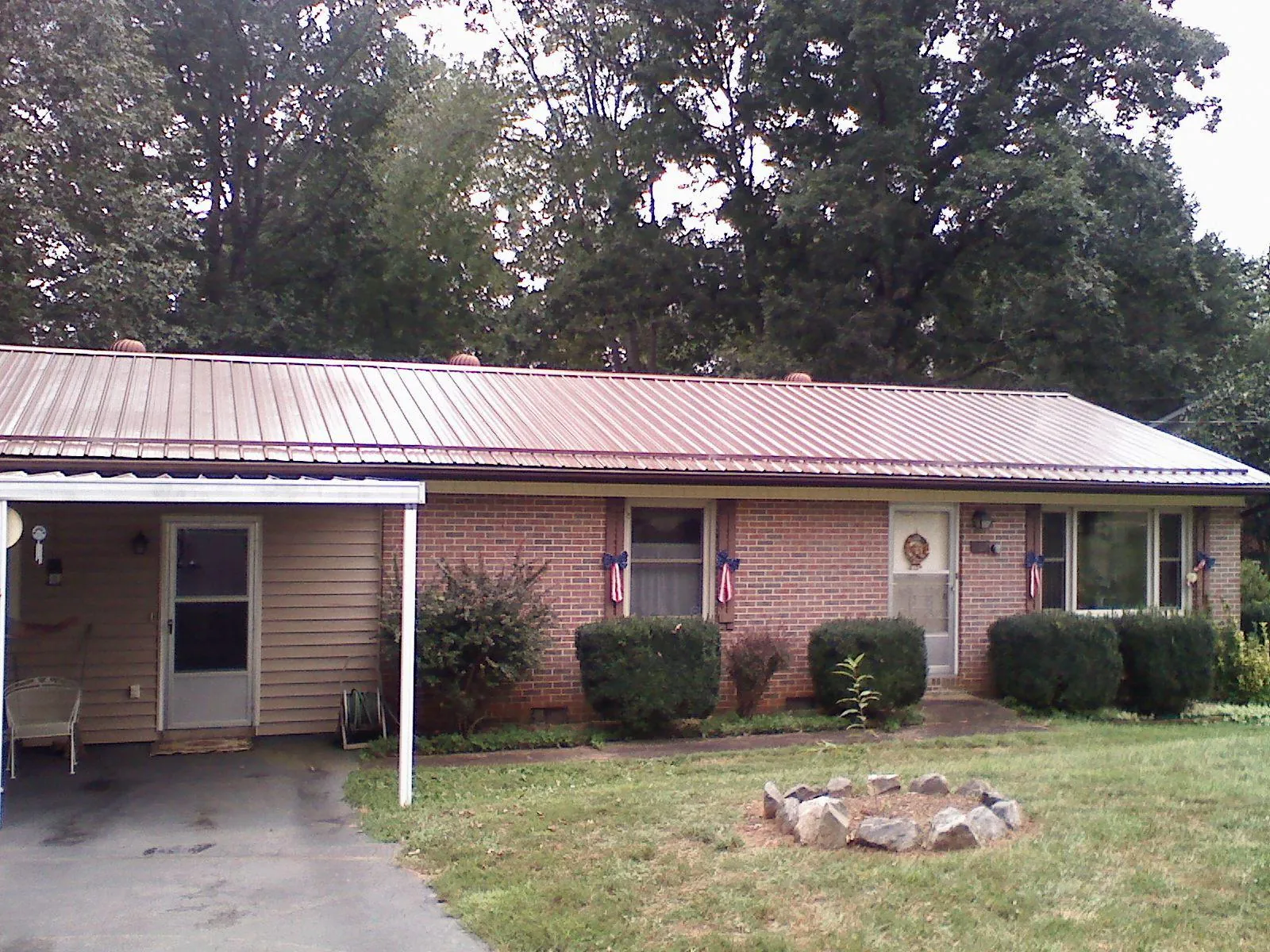 Bronze metal roof and carport on a brick ranch home — Roof Repair work by our crew in Spurger